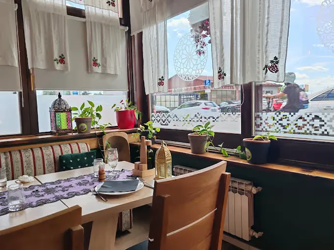 Stol uz prozor u restoranu Baščaršija, s bosanskim detaljima i fenjerom